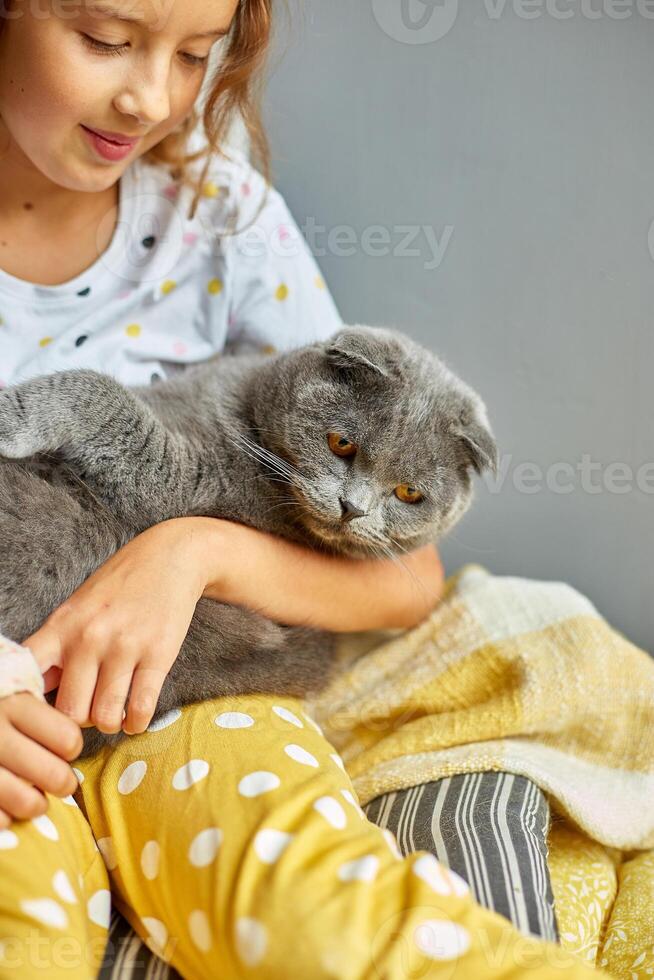 Teen girl with a broken arm orthopedic cast play with cat photo