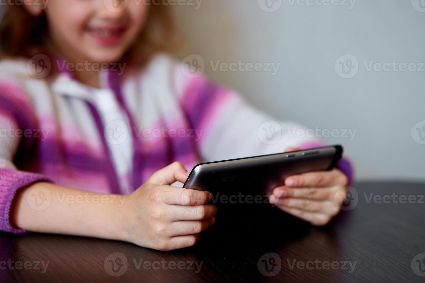 Young Girl Smiling While Engaging With Digital Tablet Indoors photo