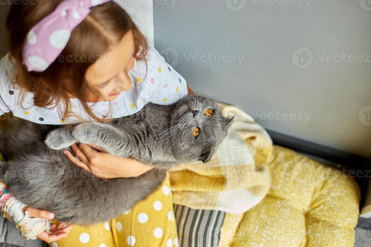 Teen girl with a broken arm orthopedic cast play with cat photo