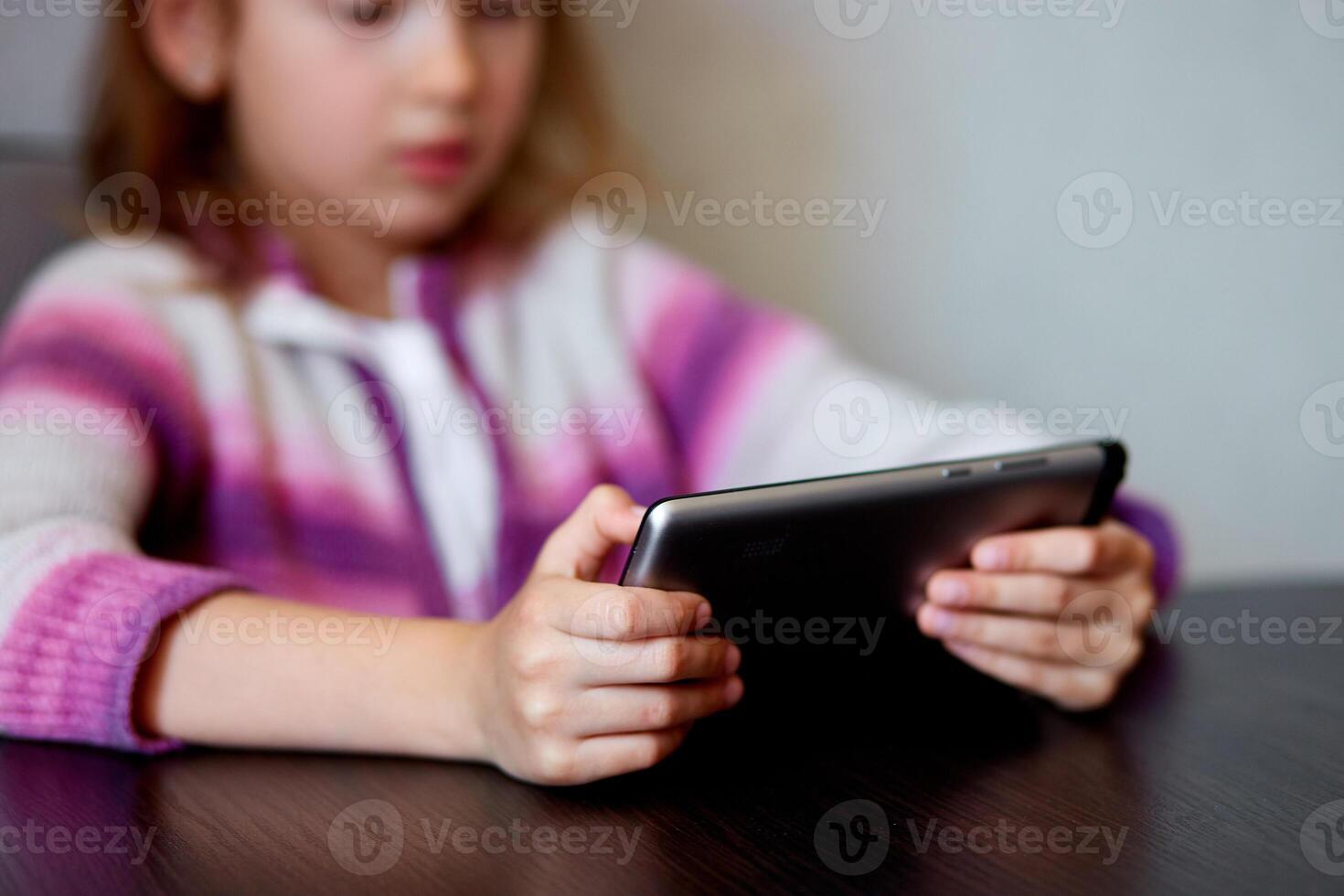 Young Girl Smiling While Engaging With Digital Tablet Indoors photo