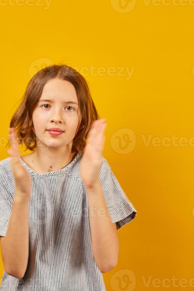 Teenage Schoolgirl Clapping Hands Against a Bright Yellow Background During Daytime photo