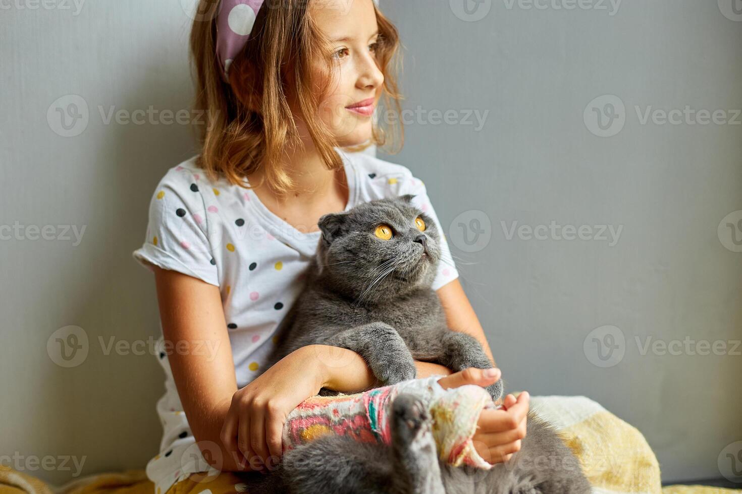 Teen girl with a broken arm orthopedic cast play with cat photo