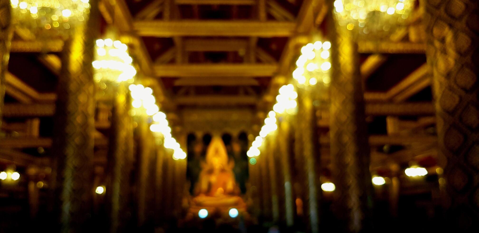 Blurred Big golden Buddha statue for background at Wat Phra Sri Rattana Mahatat Woramahawihan or Wat Yai temple in Phitsanulok, Thailand. Religion, Buddhist, Landmark and Wallpaper concept. photo