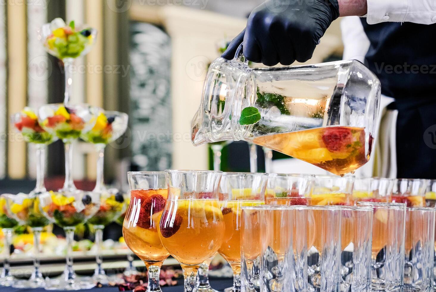 Bartender Pouring Fruit Punch into Glasses photo