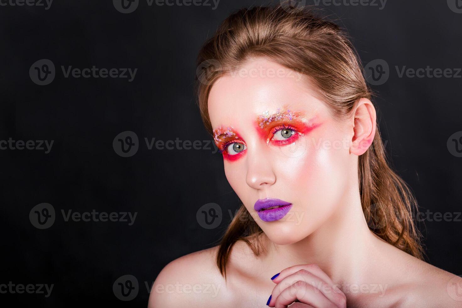 Young Woman with Artistic Makeup on Dark Background photo