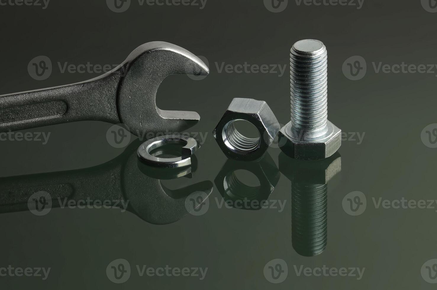 Wrench and mechanical fasteners on reflective surface photo