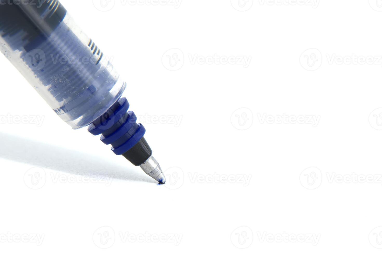Close-up of a ballpoint pen tip on white paper for writing and office supplies photo