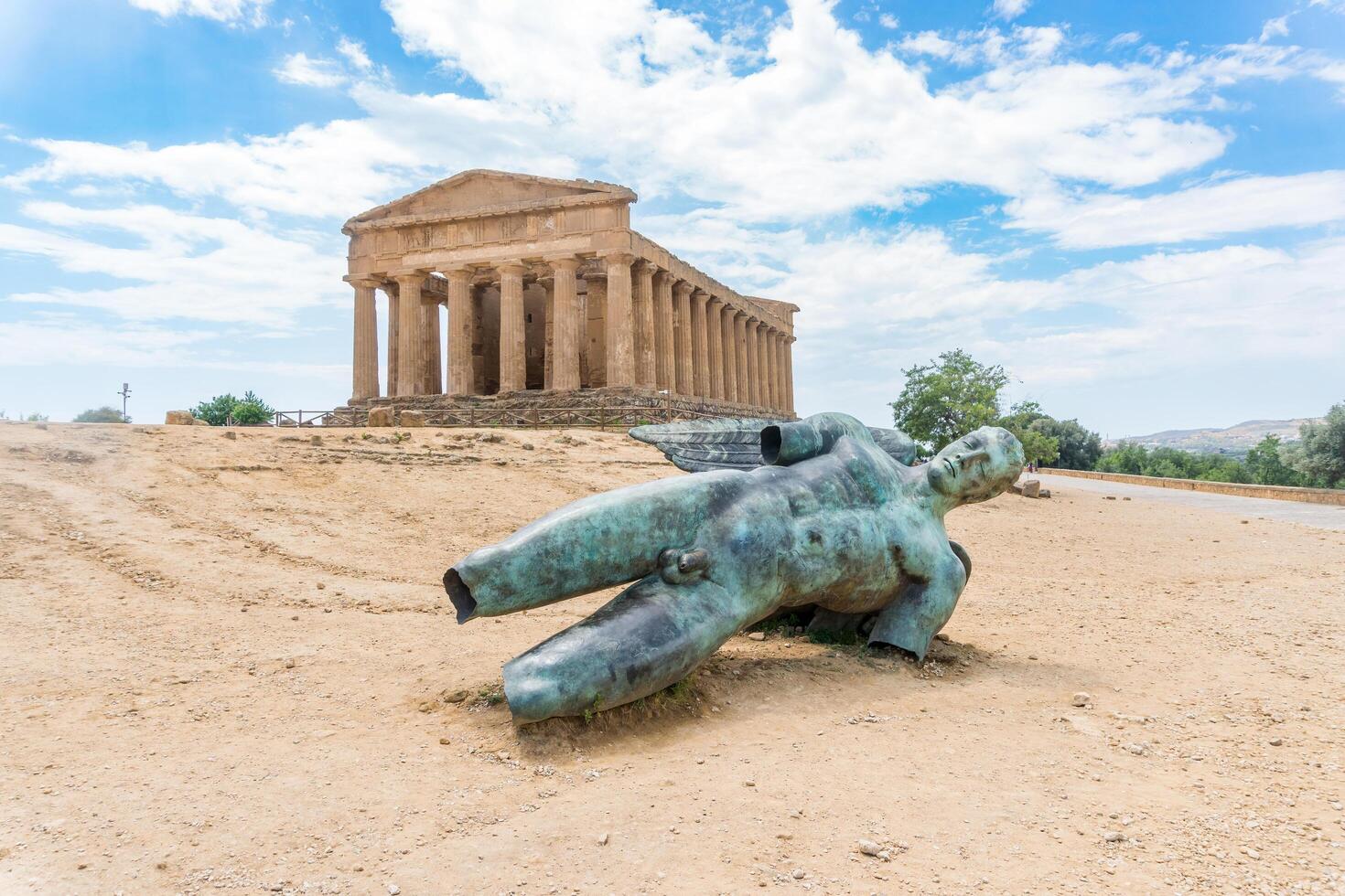 Agrigento, Italy-May 10, 2022-The Temple of Concordia and fallen Icarus inside the valley of the temples, an archaeological park near Agrigento during a sunny day photo