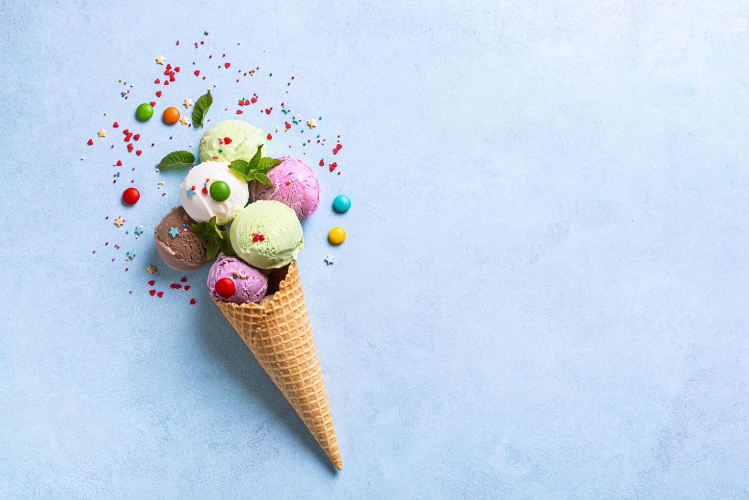 Ice cream cone with various scoops and sprinkles photo