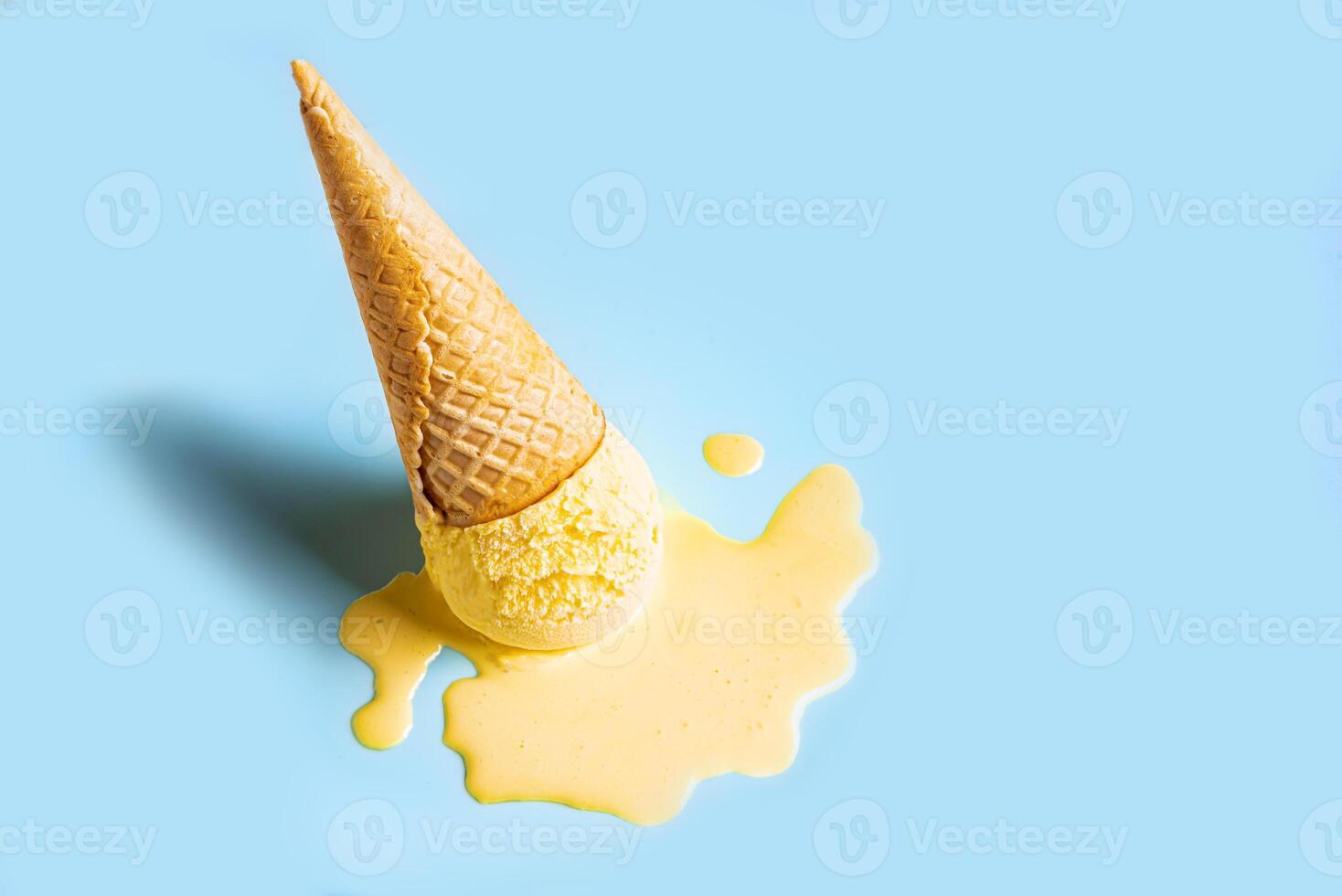Yellow mango ice cream melting and spilling photo