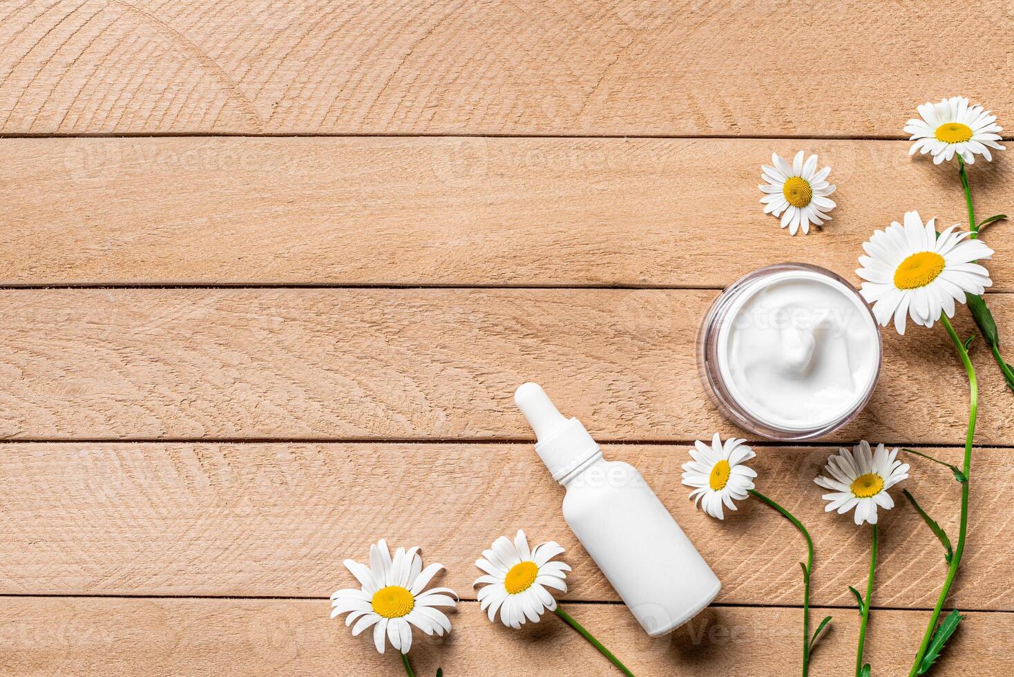 Natural organic face cream and serum with chamomile flowers photo