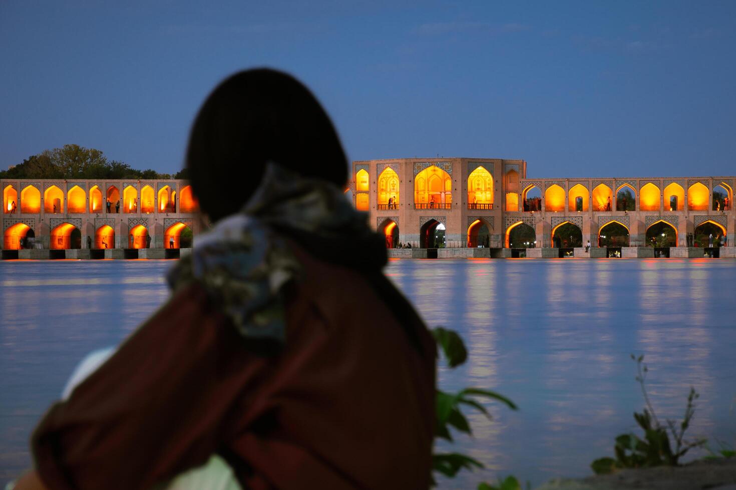 Isfahan, Iran - 15th june, 2022 - tourist visit look at famous travel destination in Iran - Old Khajoo bridge, across the Zayandeh River in Isfahan, Iran. photo