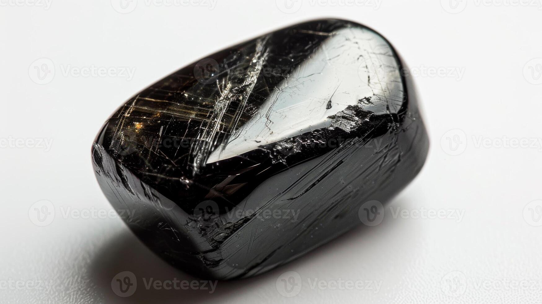 Close Up Photograph of a Single Polished Black Tourmaline Gemstone on White Background for Nature, Healing, and Jewelry Design photo