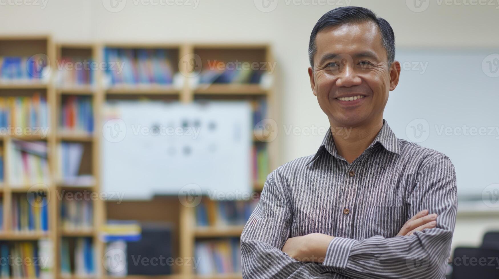 Middle Aged Indonesian Male Teacher Smiling in Classroom, Education Concept, Diversity Inclusion for Educational Content photo