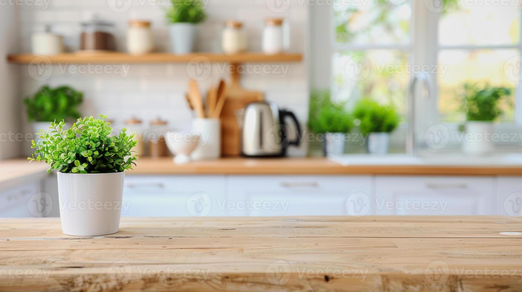 wooden kitchen desk with plant pot in front of modern blurred white kitchen in background photo
