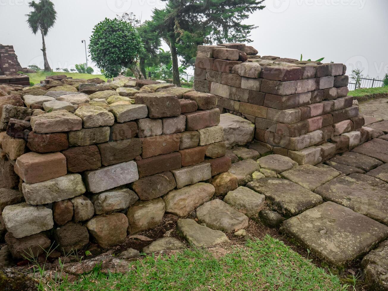 piles of ancient stones in the park area which are the ruins of temples in the past photo