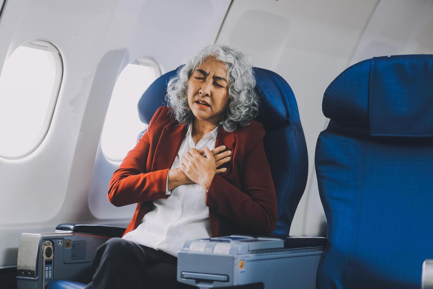 Mature with headache with nausea feeling sick while sitting in the airplane , Passengers near the window. photo