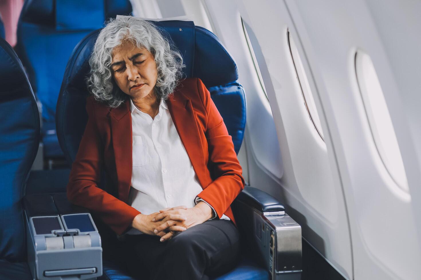 Mature with headache with nausea feeling sick while sitting in the airplane , Passengers near the window. photo