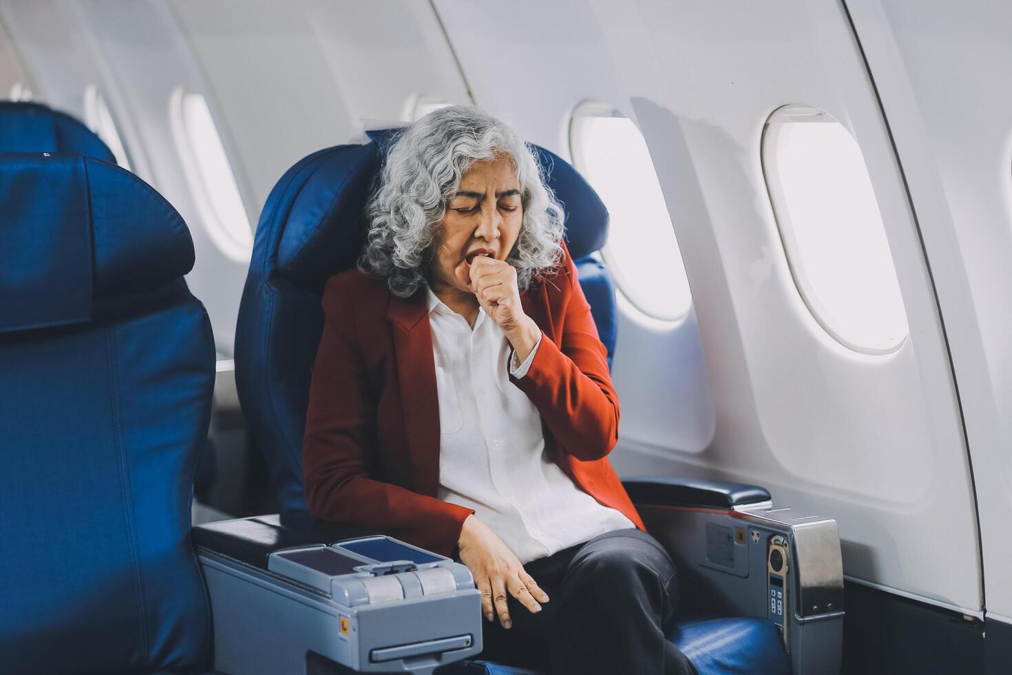 Mature with headache with nausea feeling sick while sitting in the airplane , Passengers near the window. photo
