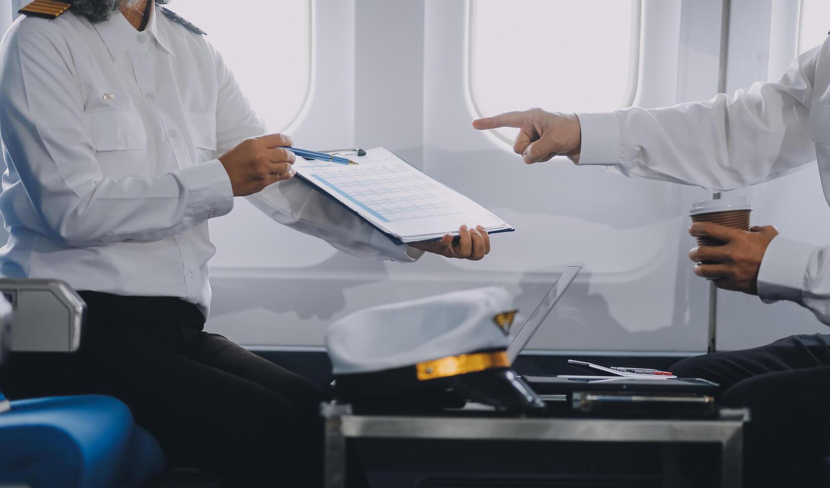 Professional pilot woman in uniform has teamwork meeting for success flight in aviation business. Young female captain instructor sitting in office and working or training commercial airline crew. photo