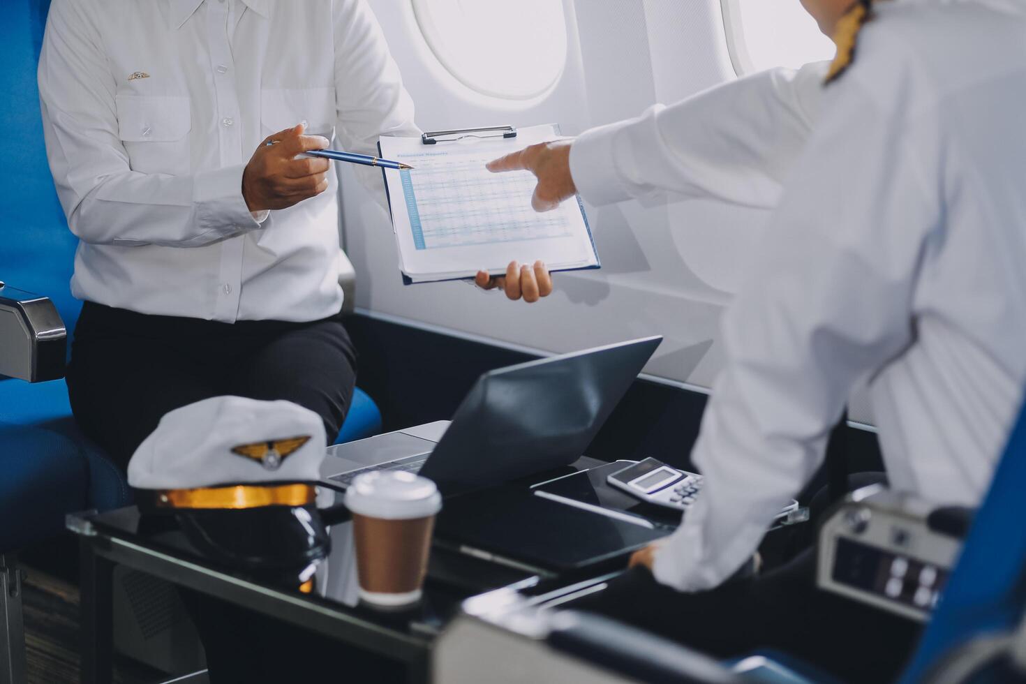 Professional pilot woman in uniform has teamwork meeting for success flight in aviation business. Young female captain instructor sitting in office and working or training commercial airline crew. photo