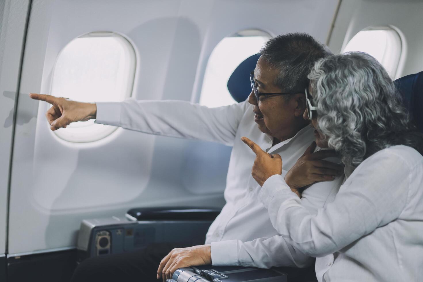 Happy elderly senior couple of travelers with suitcase in airport photo