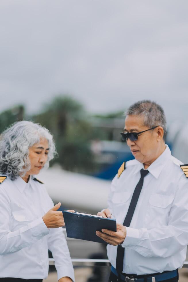 Professional pilot woman in uniform has teamwork meeting for success flight in aviation business. Young female captain instructor sitting in office and working or training commercial airline crew. photo