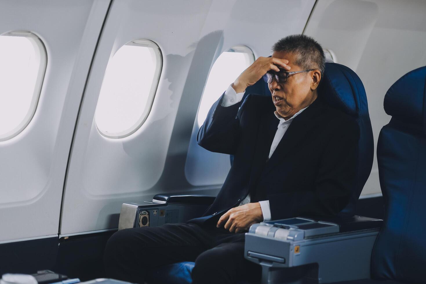 headache in the airplane, man passenger afraid and feeling bad during the flight in plane photo