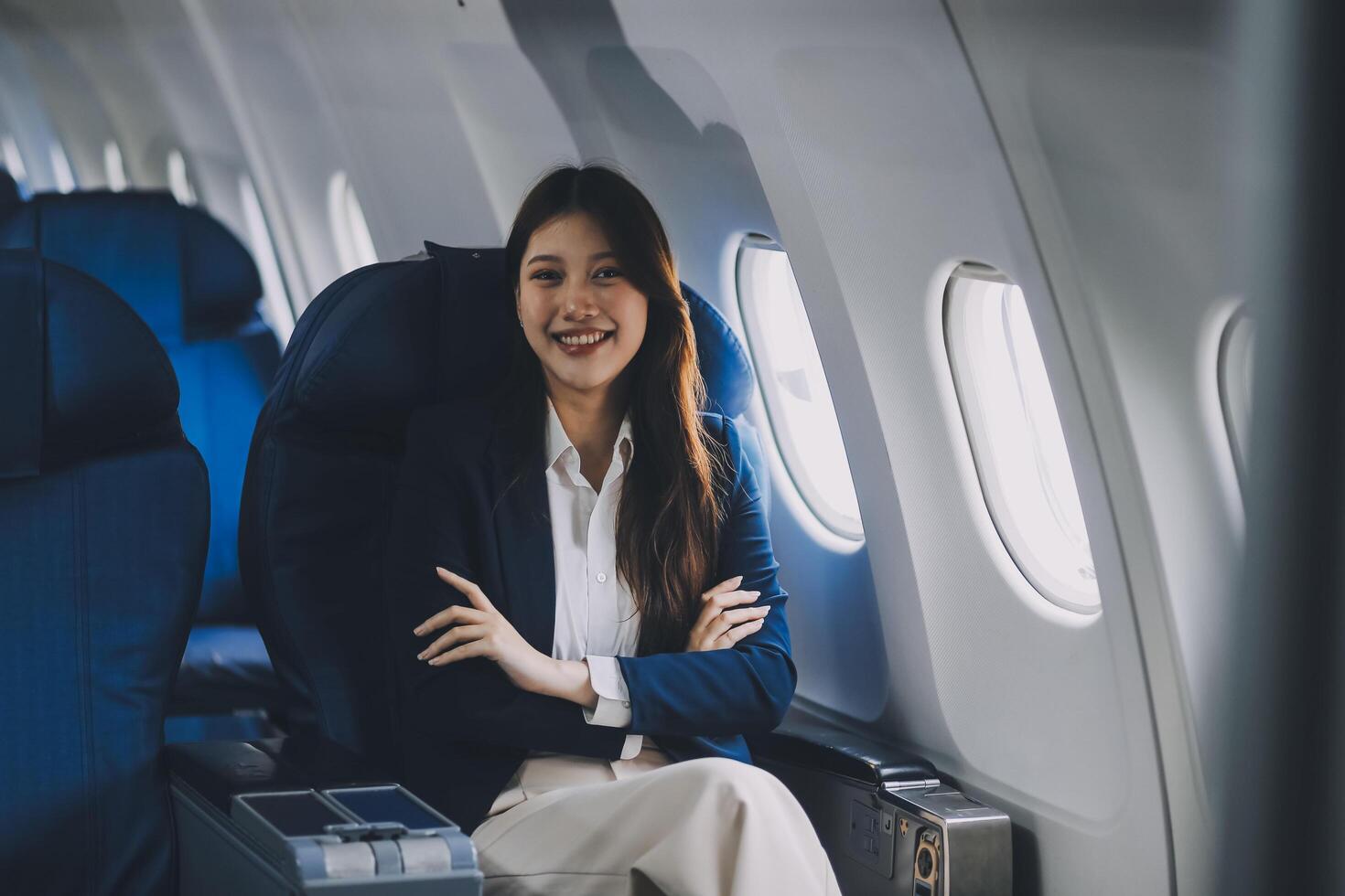 Young Asian female tourist traveling alone on a plane is drinking hot coffee and looking out the window. photo