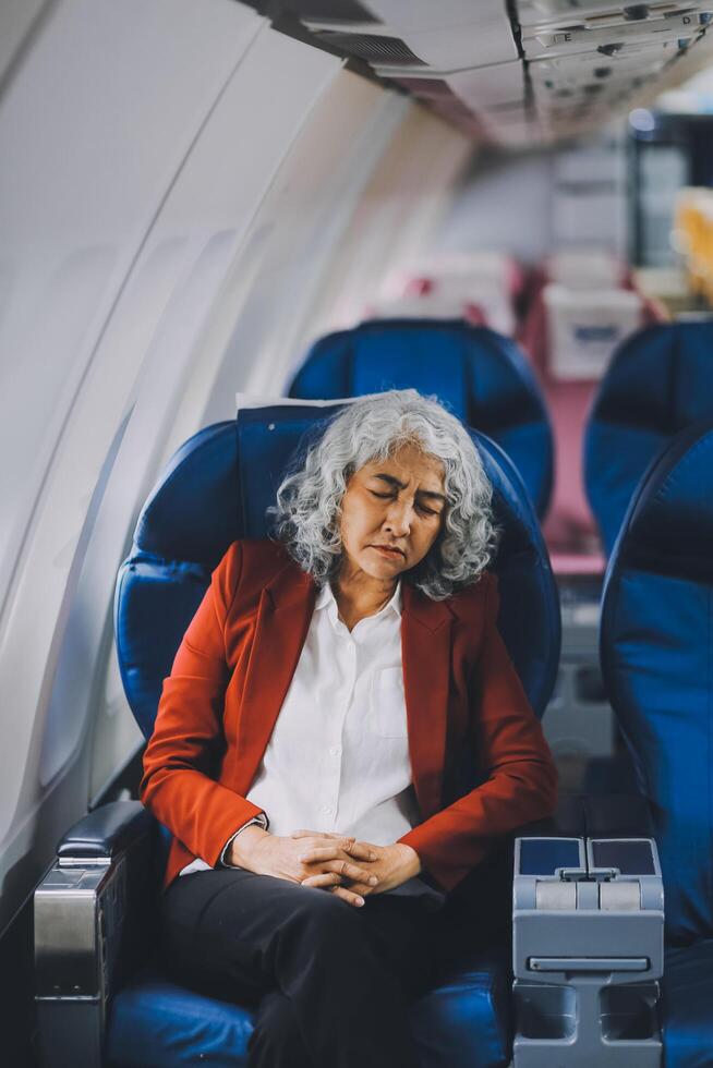 Mature with headache with nausea feeling sick while sitting in the airplane , Passengers near the window. photo