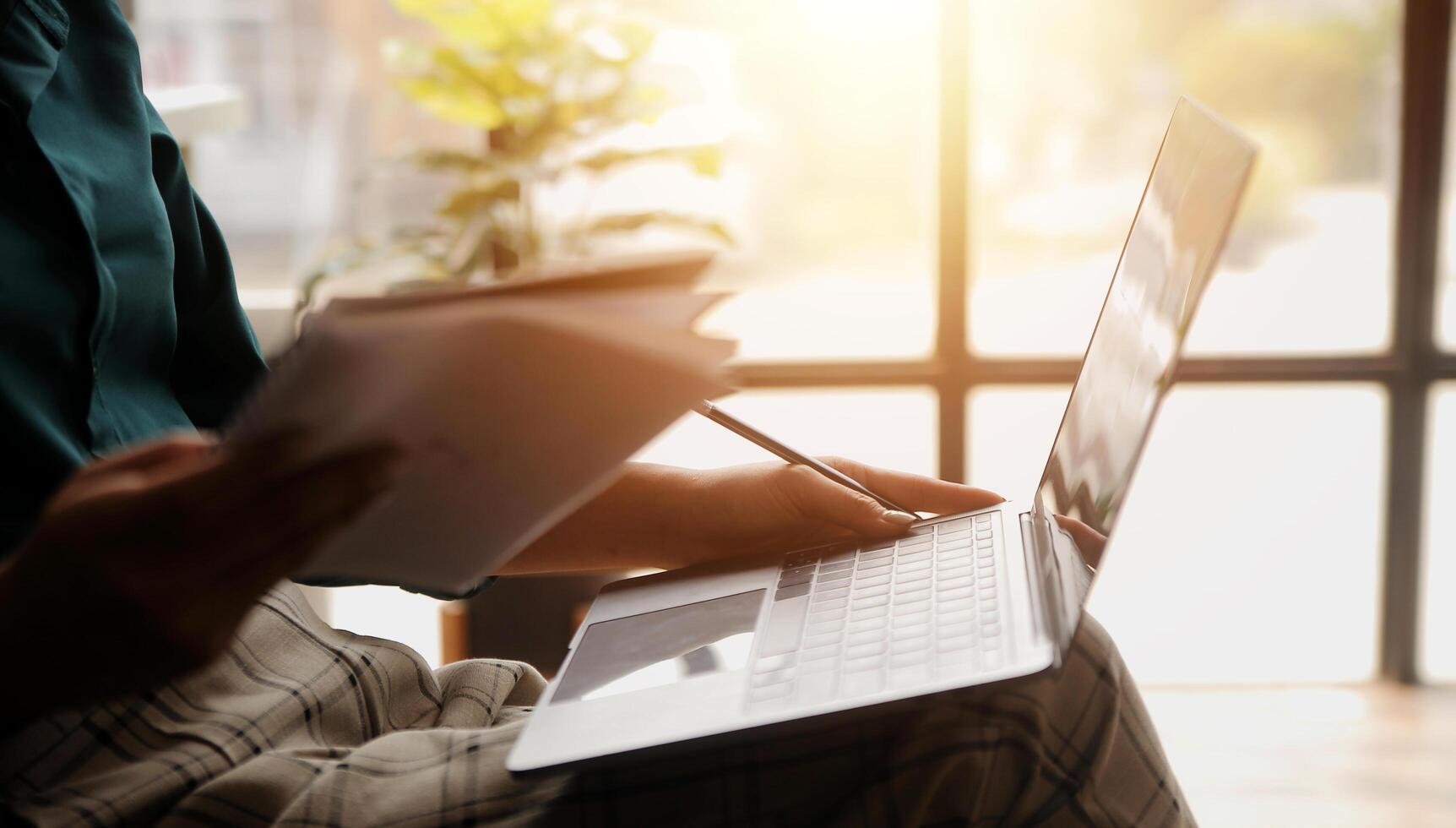 Distracted from work worried young woman sitting on couch with laptop, thinking of problems. Pensive unmotivated lady looking at window, feeling lack of energy, doing remote freelance tasks at home. photo