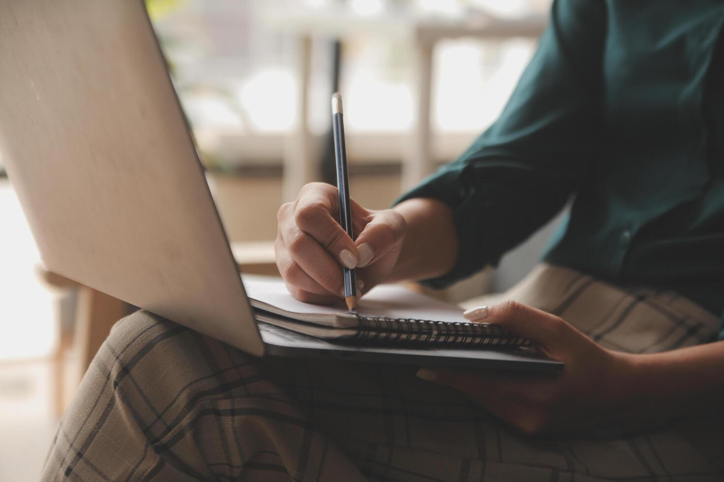 Distracted from work worried young woman sitting on couch with laptop, thinking of problems. Pensive unmotivated lady looking at window, feeling lack of energy, doing remote freelance tasks at home. photo