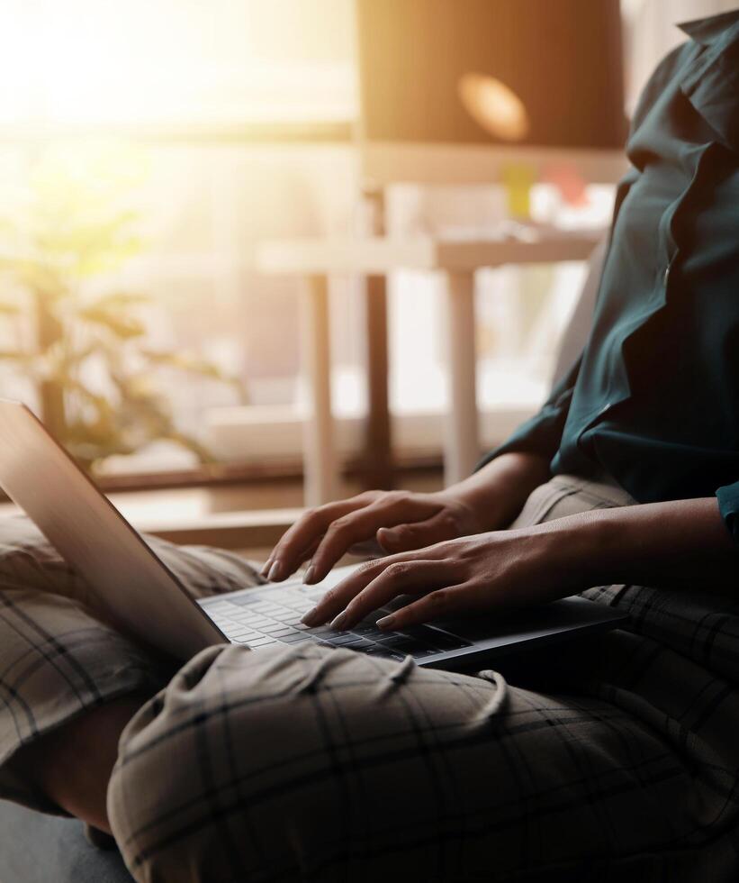Distracted from work worried young woman sitting on couch with laptop, thinking of problems. Pensive unmotivated lady looking at window, feeling lack of energy, doing remote freelance tasks at home. photo