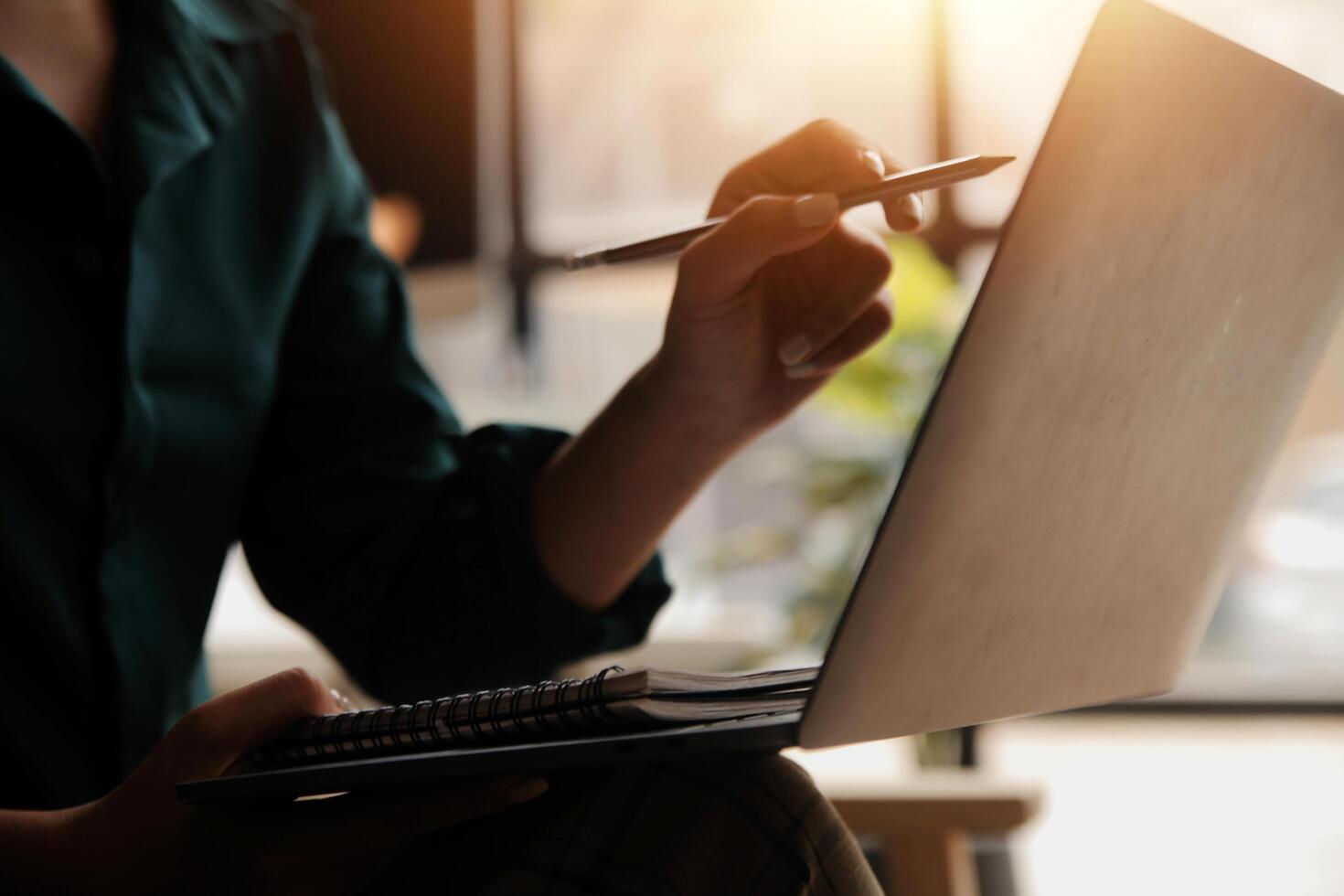 Distracted from work worried young woman sitting on couch with laptop, thinking of problems. Pensive unmotivated lady looking at window, feeling lack of energy, doing remote freelance tasks at home. photo