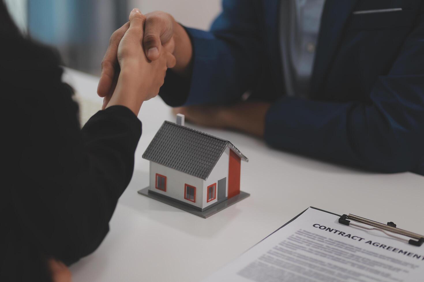 Estate agent shaking hands with customer after contract signature photo