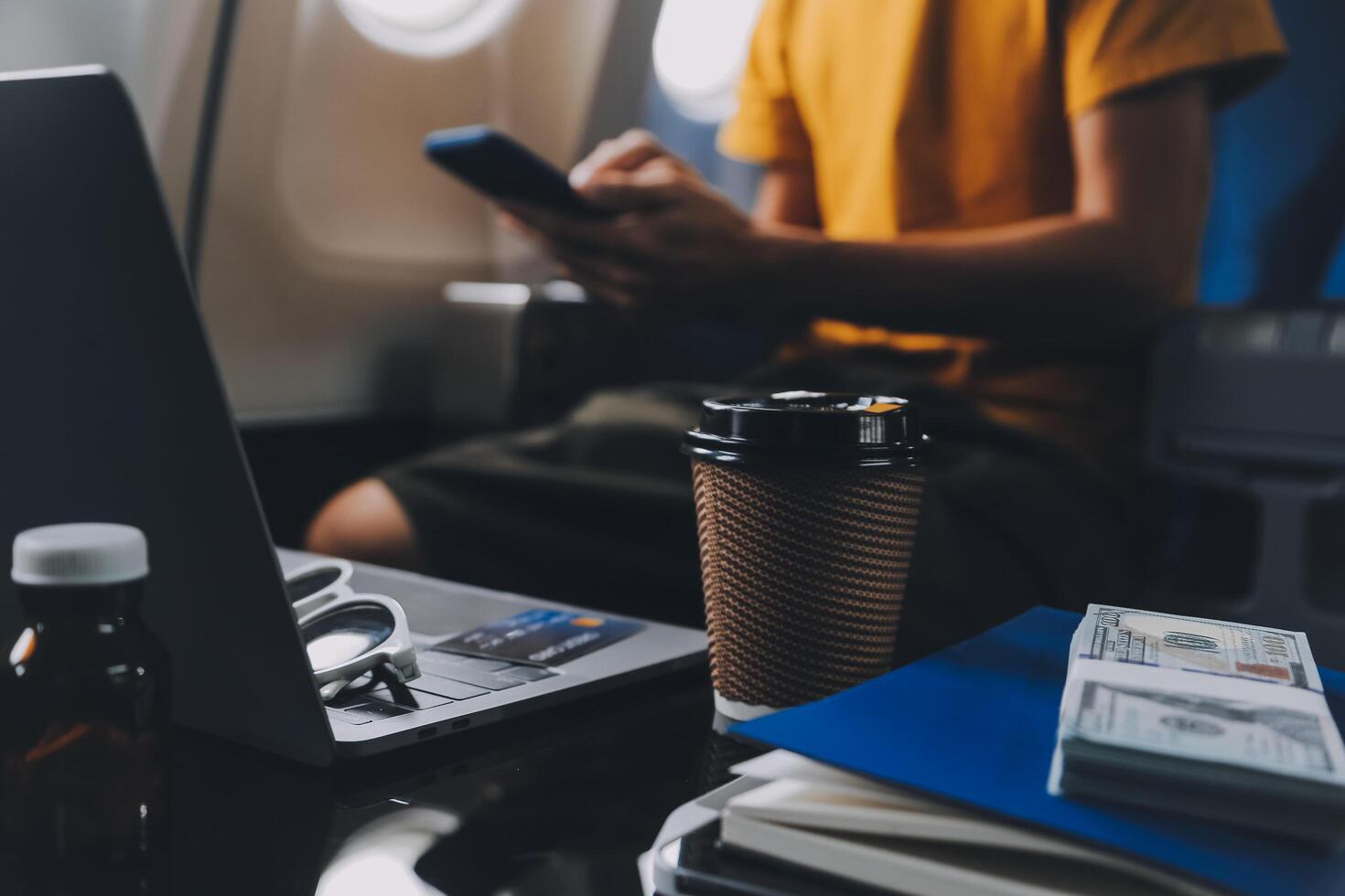 Attractive Asian businesswoman traveling on airplane playing with mobile phone while sitting in cabin. photo