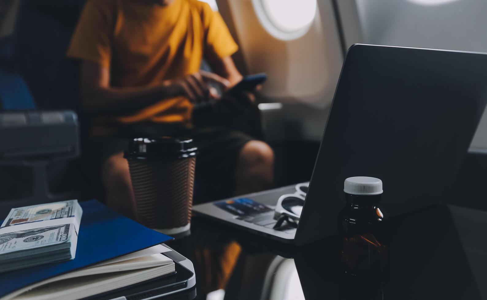 Attractive Asian businesswoman traveling on airplane playing with mobile phone while sitting in cabin. photo