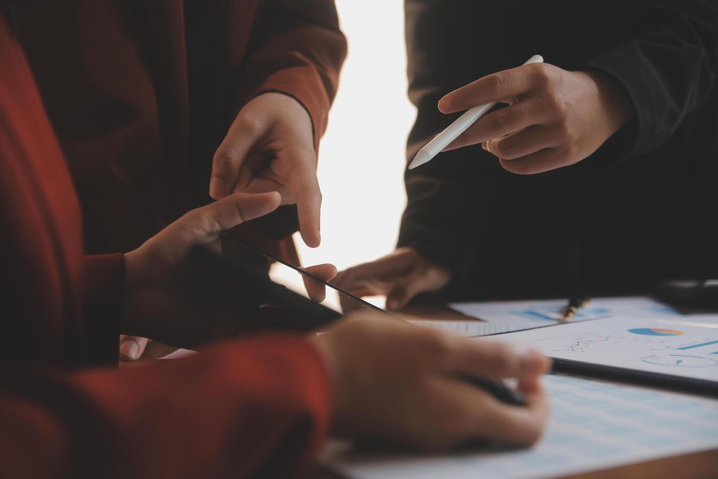 Group of confident business people point to graphs and charts to analyze market data, balance sheet, account, net profit to plan new sales strategies to increase production capacity. photo