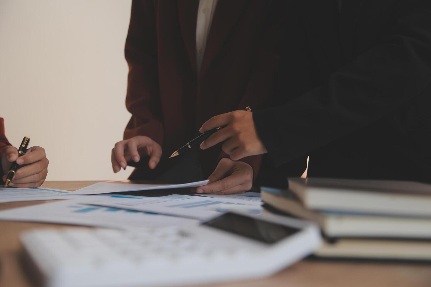 Group of confident business people point to graphs and charts to analyze market data, balance sheet, account, net profit to plan new sales strategies to increase production capacity. photo