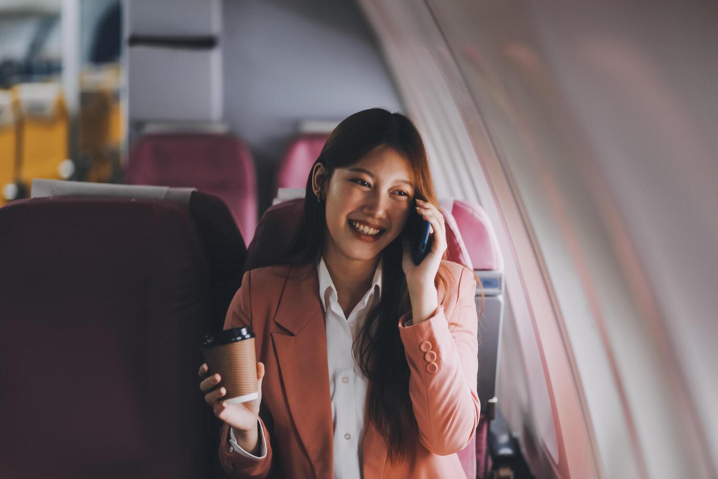 Attractive Asian female passenger of airplane sitting in comfortable seat while working laptop and tablet with mock up area using wireless connection. Travel in style, work with grace. photo