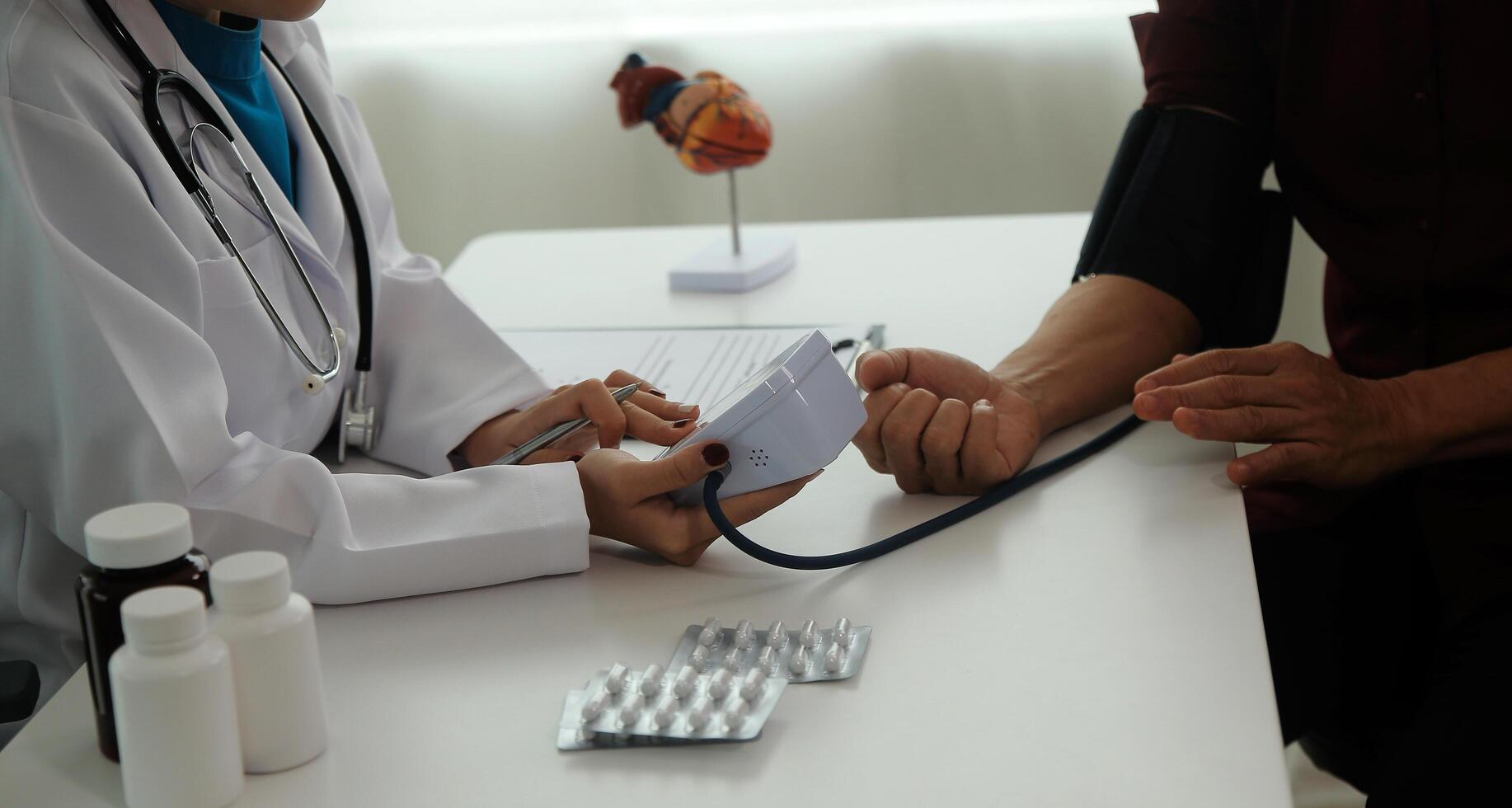 Doctor using sphygmomanometer with stethoscope checking blood pressure to a patient in the hospital. photo