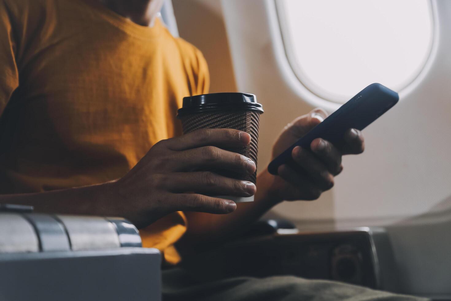 Attractive Asian businesswoman traveling on airplane playing with mobile phone while sitting in cabin. photo