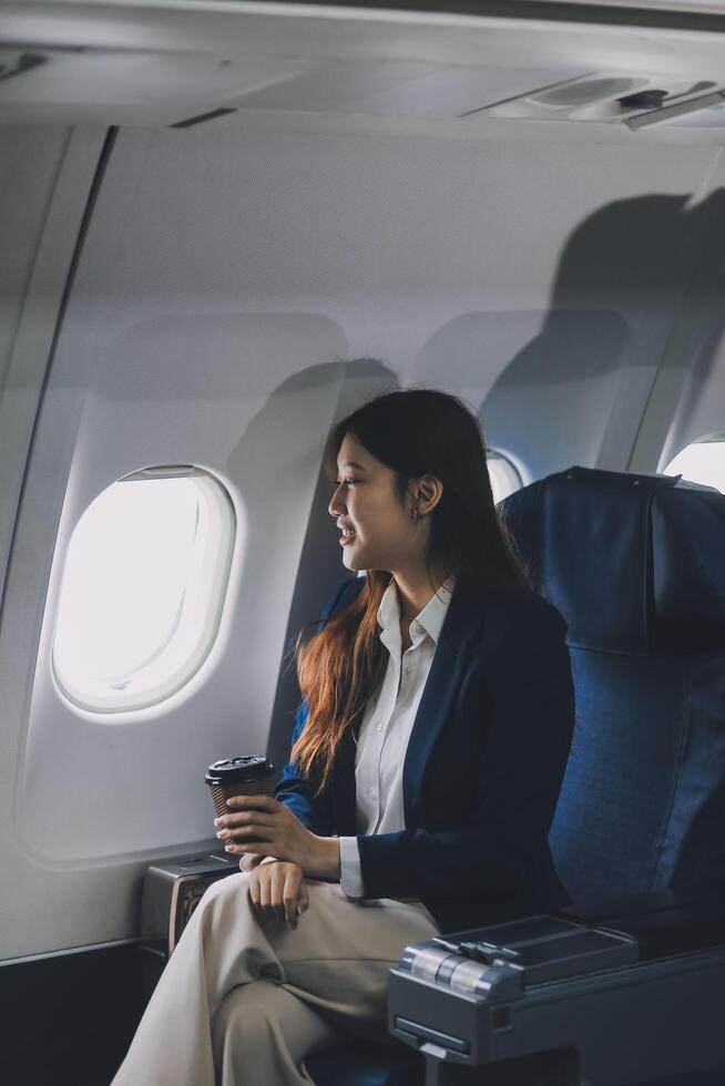 Asian woman sitting in a seat in airplane and looking out the window going on a trip vacation travel concept.Capture the allure of wanderlust with this stunning image photo