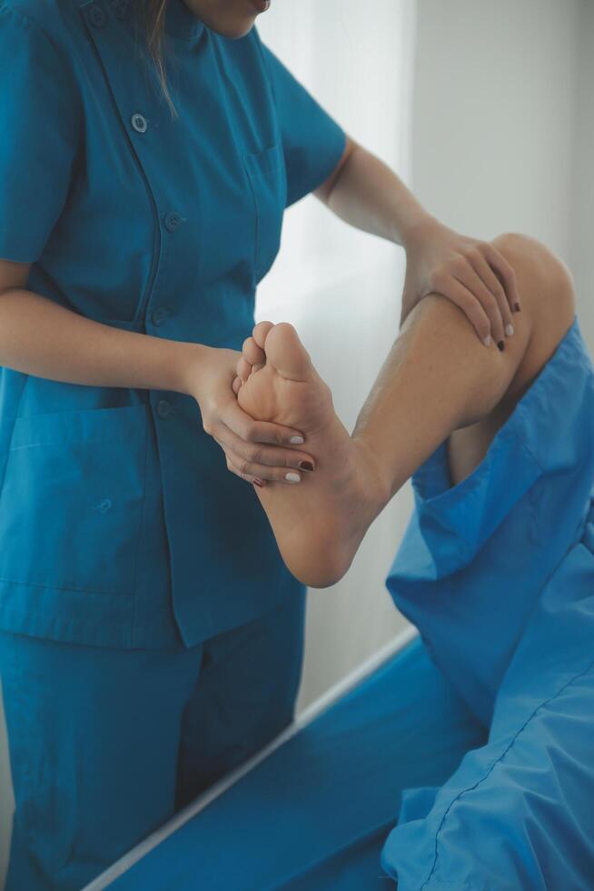 Physical therapists work with patients in close-up clinics. The concept of rehabilitation of physical health, the doctor gives advice to the patient. Ankle problems and muscle injuries photo