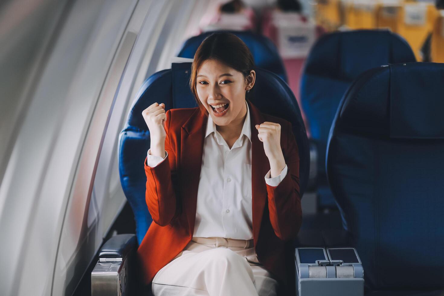 A young Asian woman, seated as an airplane passenger, contemplates dollar bills, reflecting on lucrative opportunities and aspirations towards billionaire status. photo