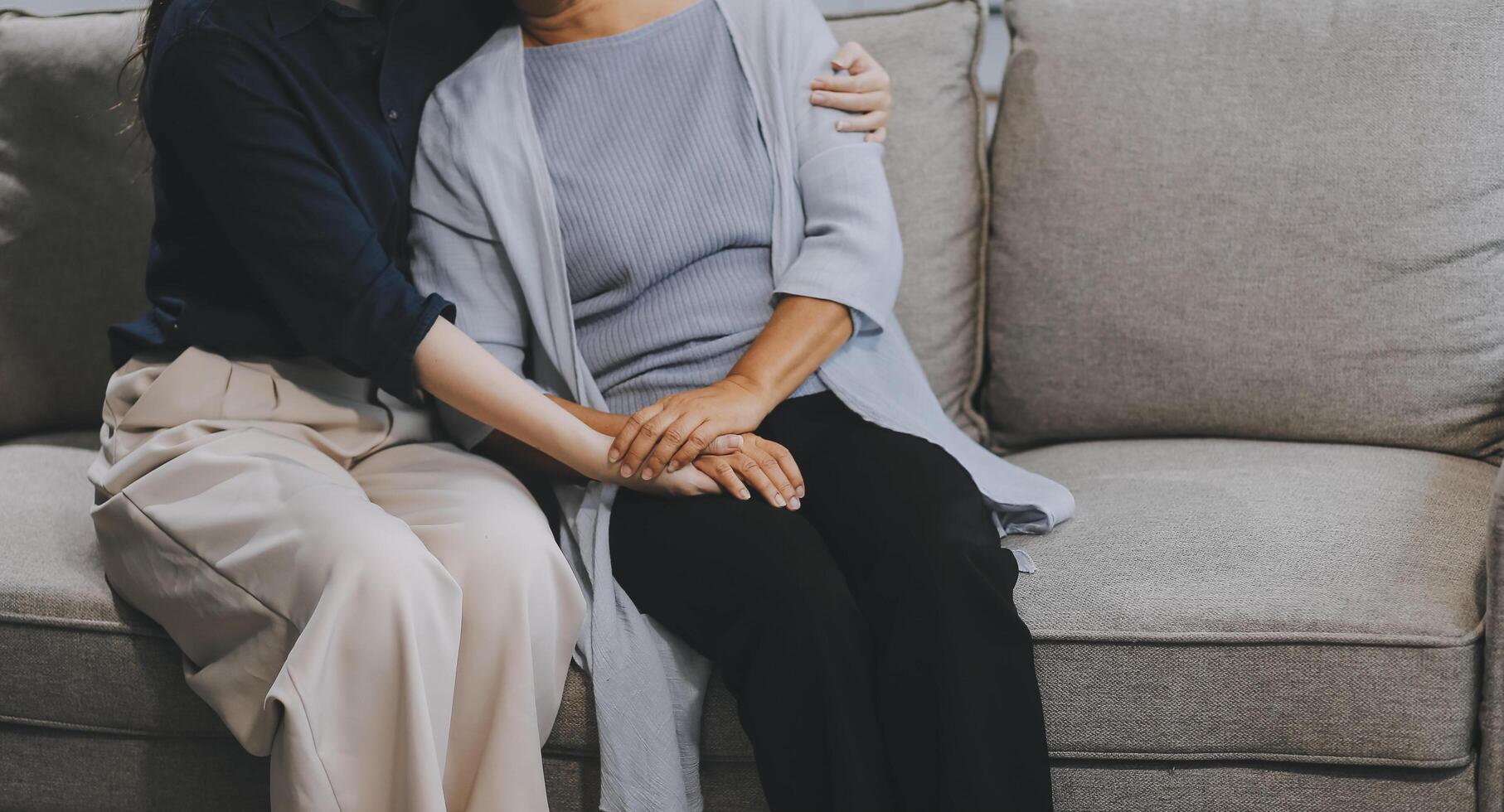 Sad teen granddaughter hugging depressed mature grandmother, giving support, help, comforting, consoling granny. Teenage daughter girl and middle aged mother going through family problems photo