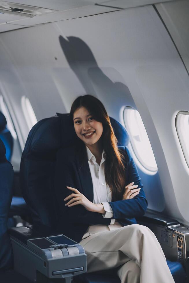 Young Asian female tourist traveling alone on a plane is drinking hot coffee and looking out the window. photo