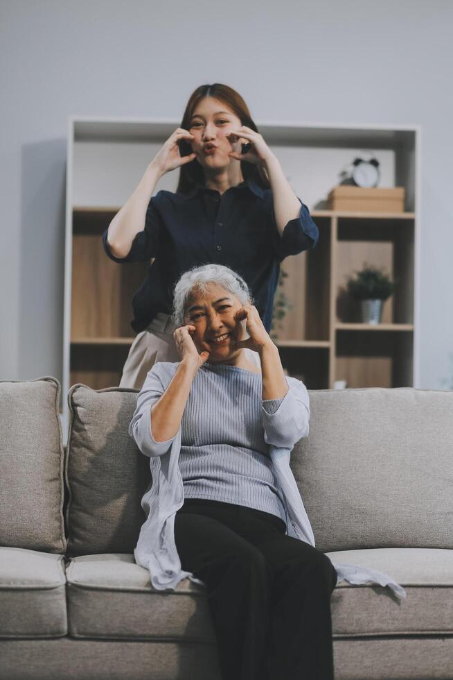 Adult daughter old mom hugging sit on couch enjoy pleasant positive talk, remembering funny occasion from life spend weekend together, caring about older generation relatives express attention concept photo