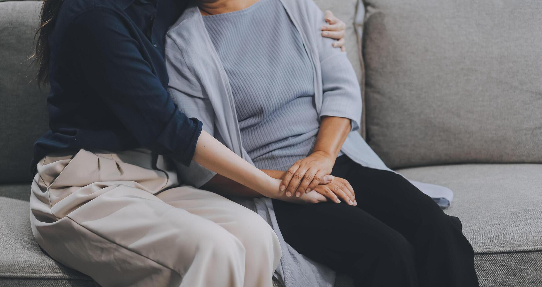 Sad teen granddaughter hugging depressed mature grandmother, giving support, help, comforting, consoling granny. Teenage daughter girl and middle aged mother going through family problems photo