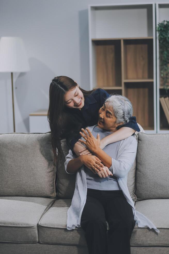 Adult daughter old mom hugging sit on couch enjoy pleasant positive talk, remembering funny occasion from life spend weekend together, caring about older generation relatives express attention concept photo